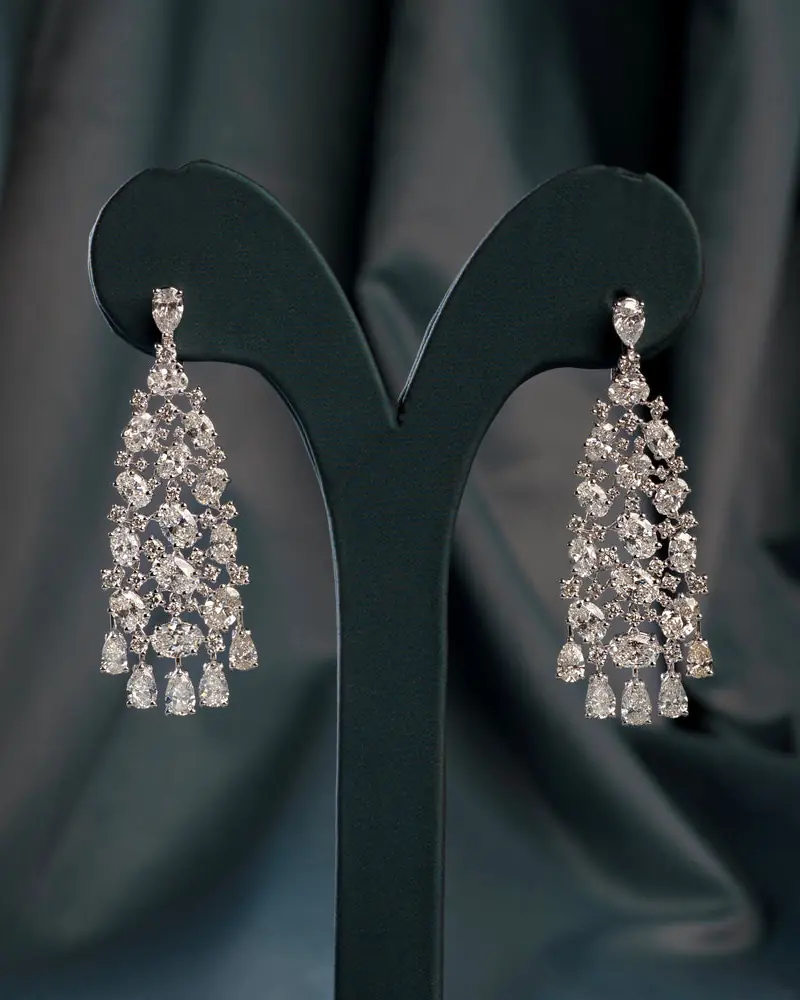 Cascading pear and marquise diamond chandelier earrings on a velvet stand
