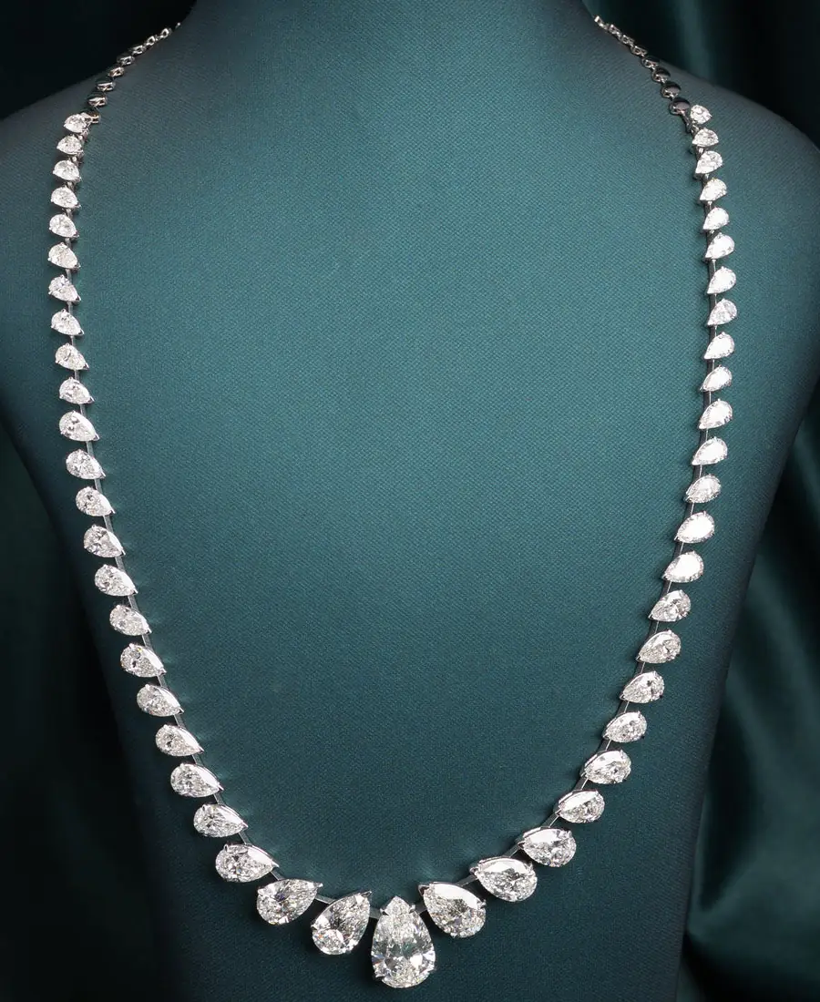 Pear-cut lab-grown diamond tennis necklace on a green velvet bust